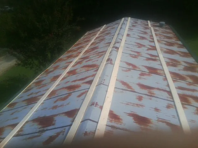 Rusted metal roof panels with new wood purlins before replacement — Storm Damage Roof Repair in Fordyce by Roofing Brothers