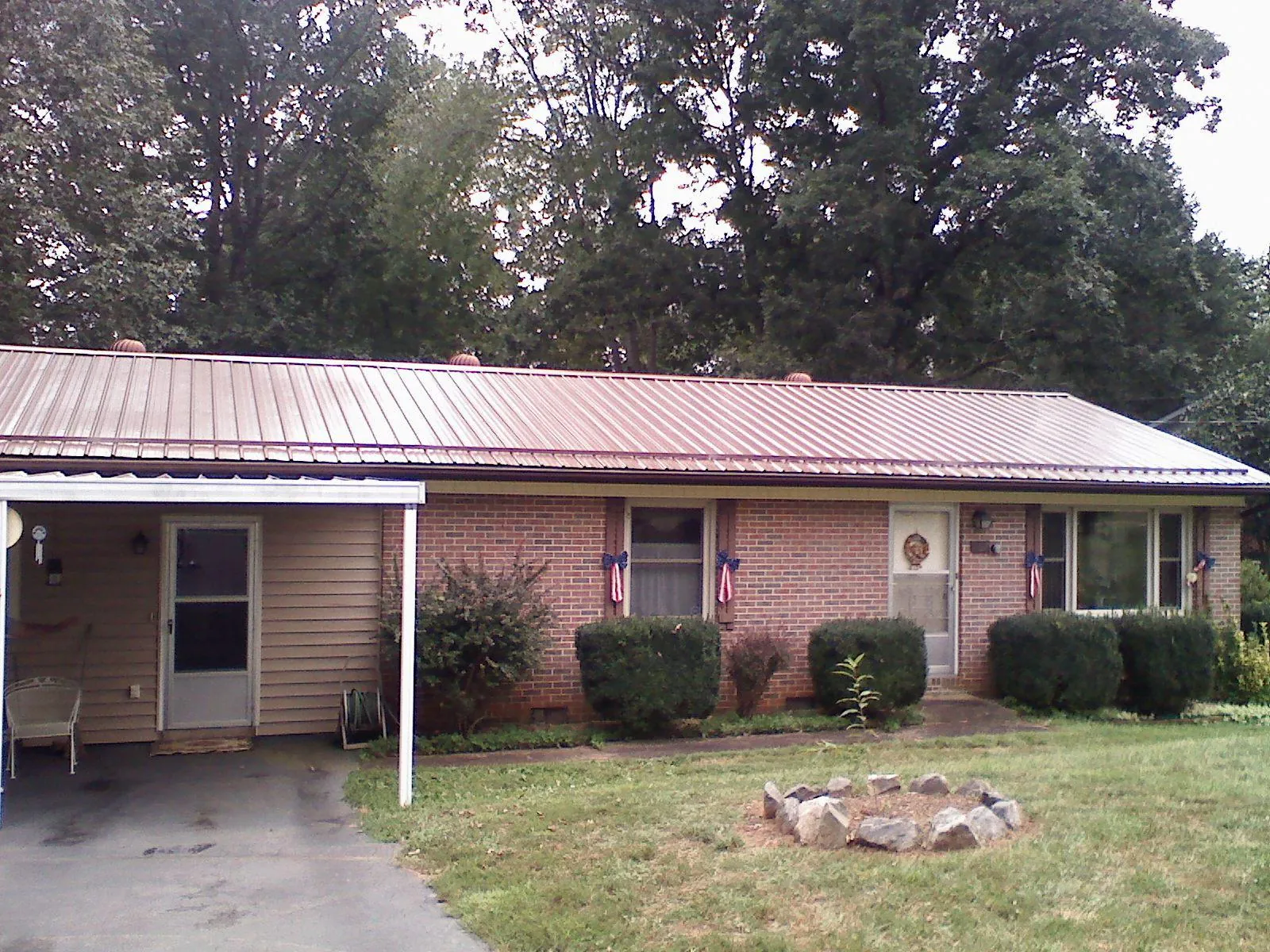 Bronze metal roof and carport on a brick ranch home — Roof Repair work by our crew in Fordyce